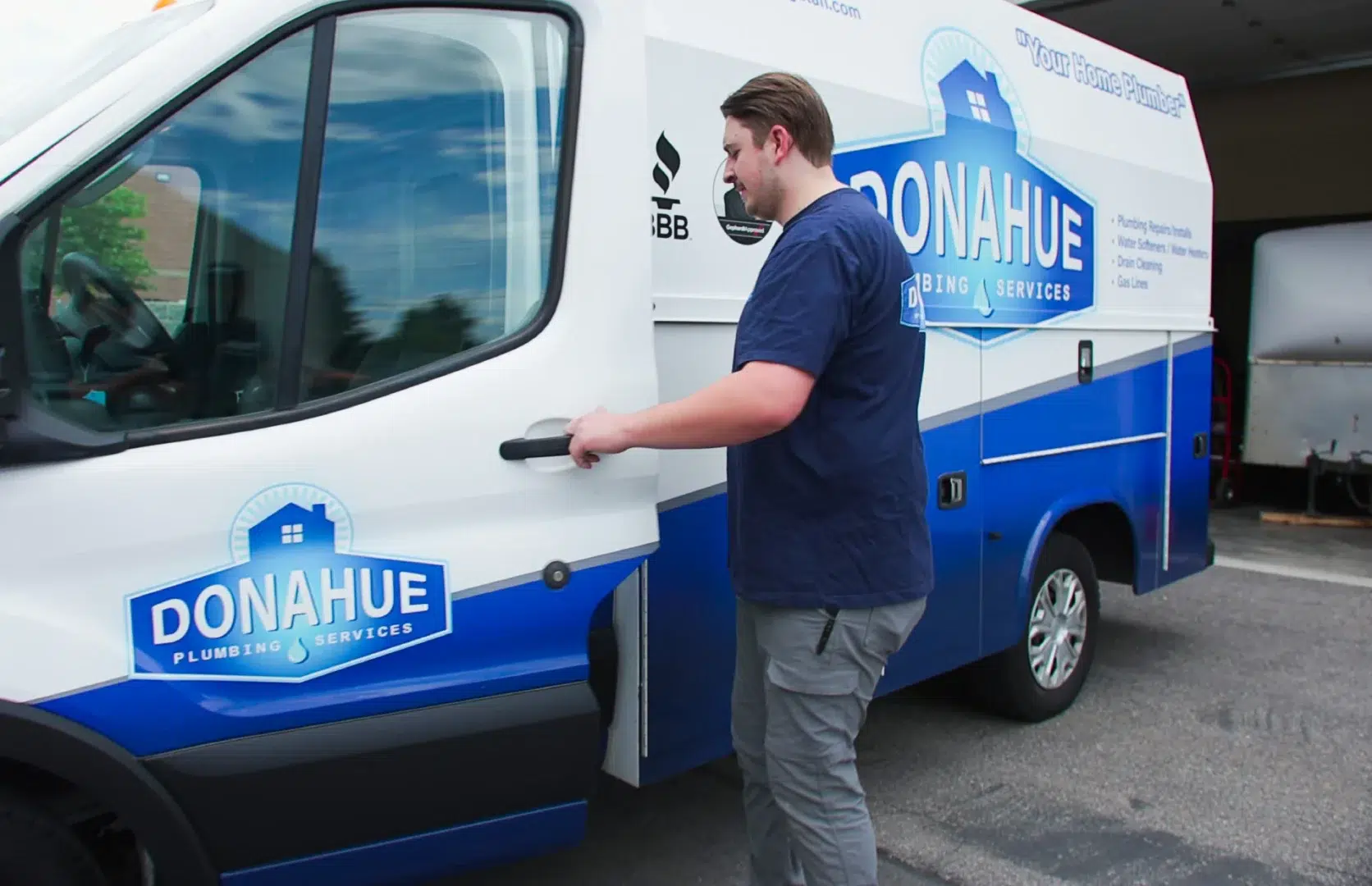 A Donahue Plumbing technician opening a branded service truck before heading to a customer's home in Utah.