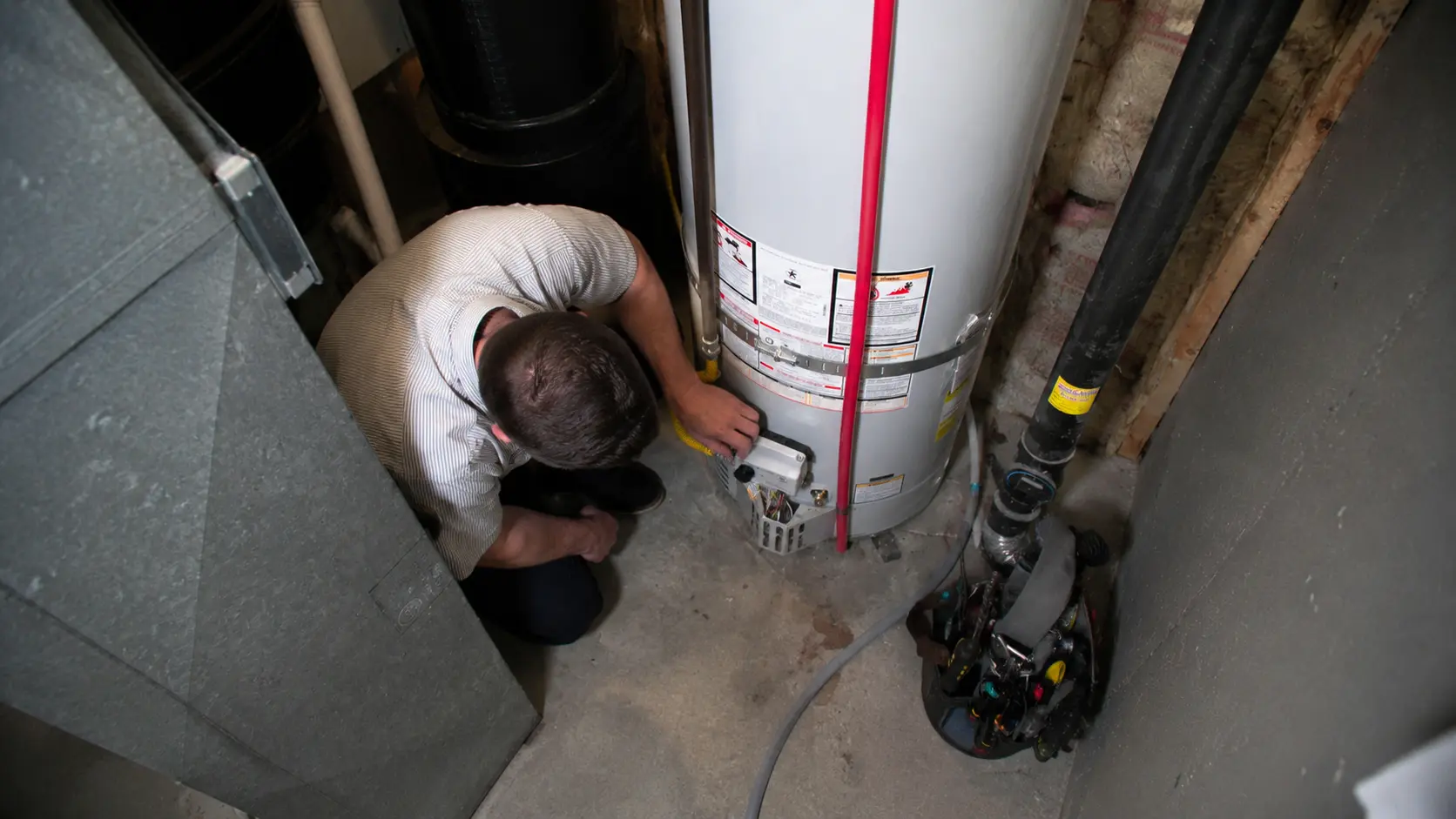 Plumber servicing a gas water heater